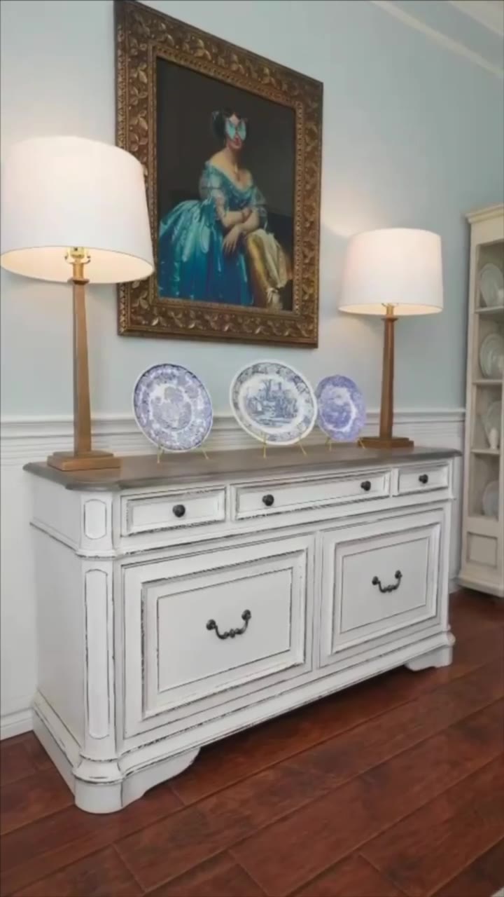 A French Country living room: antiques, blue and white, a portrait over a painted sideboard.
